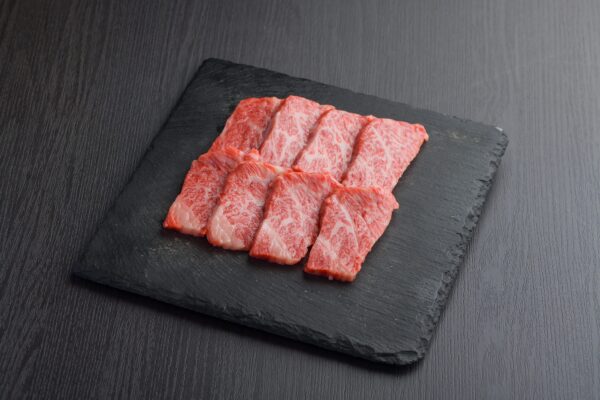 A plate of thinly sliced Halal A5 Wagyu beef, ready for grilling or pan-frying. The beef has a rich marbled appearance.